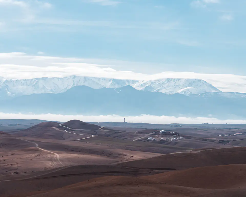 The Agafay stone desert near Marrakech, a camp below the snow-capped Atlas