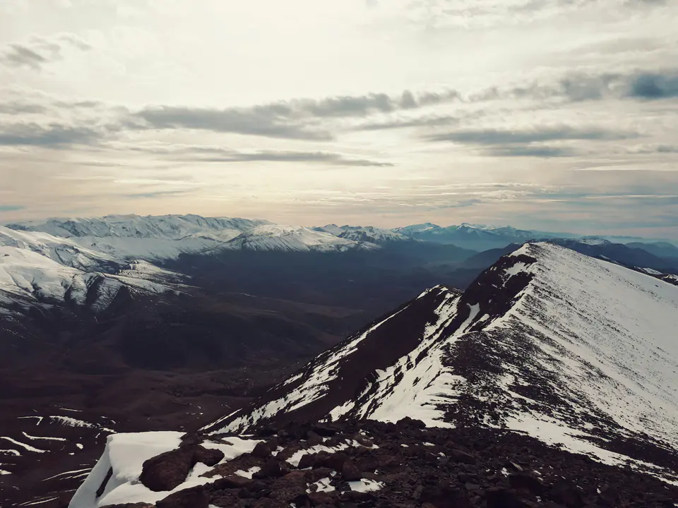 Snow-covered ridges of the High Atlas under a pale sky