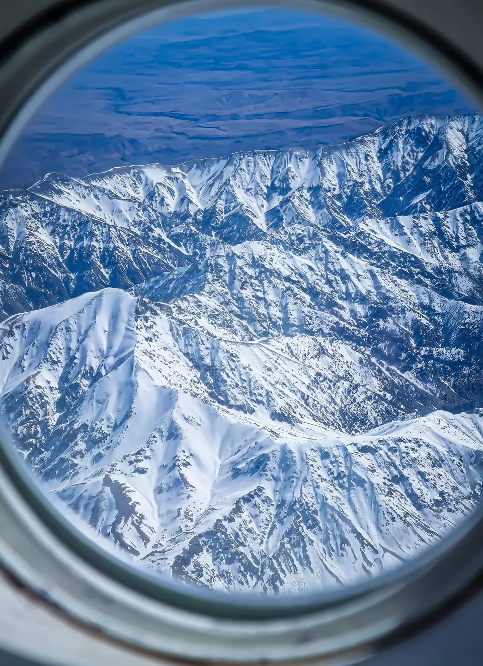 The snow-covered Atlas Mountains seen through an aircraft window