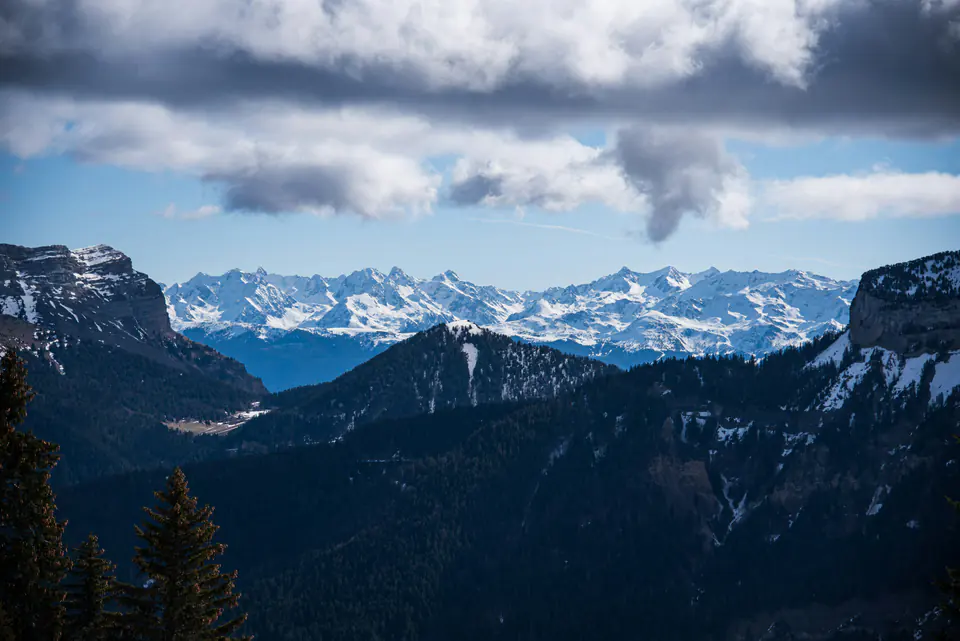Snow-covered peaks seen between the cliffs of the Chartreuse from the Charmant Som