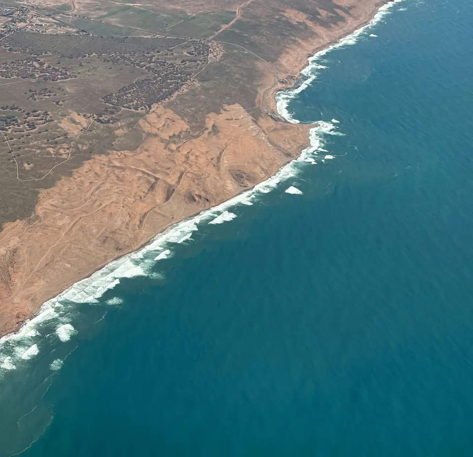 Surf along ochre cliffs on Morocco’s Atlantic coast near Agadir, seen from the air