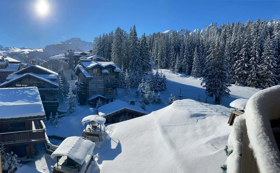 Wooden chalets under deep fresh snow in Courchevel