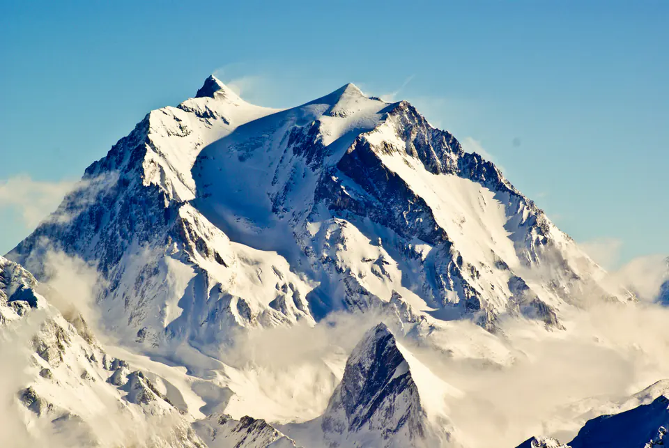 A snow-covered glaciated summit under a blue sky, seen from Courchevel