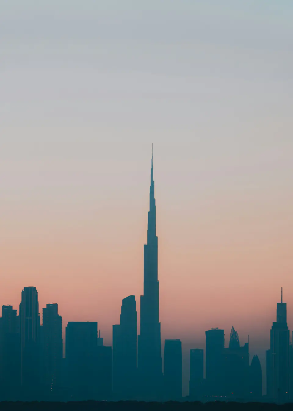 The Dubai skyline and the Burj Khalifa in silhouette at dusk