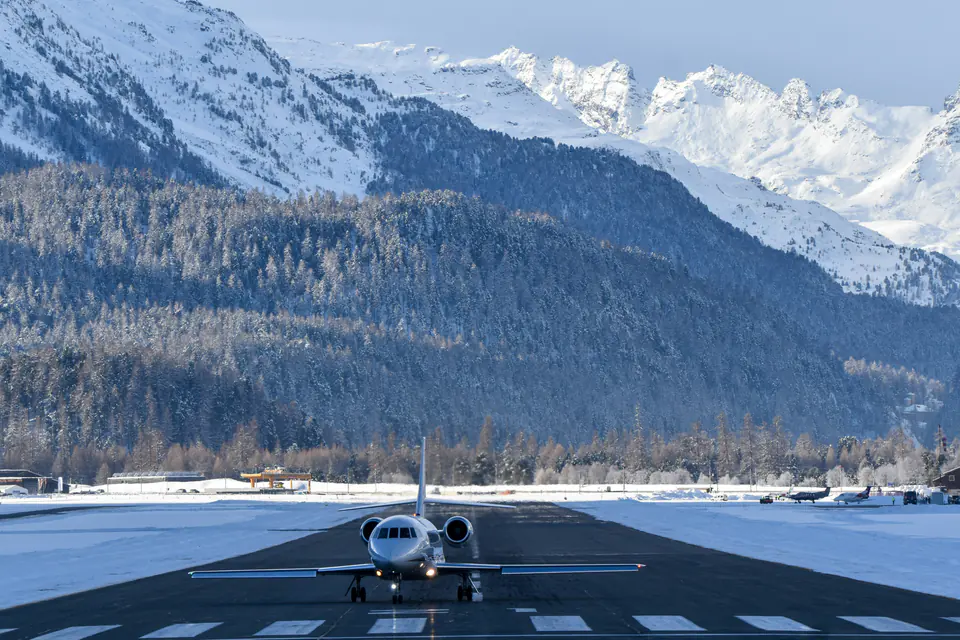 A Dassault Falcon business jet on the snowy runway of the Engadin airport at Samedan