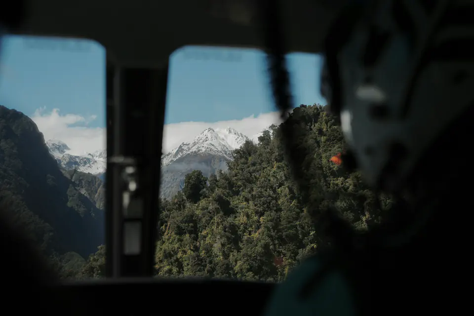Mountains and forest seen through the window of a helicopter in flight