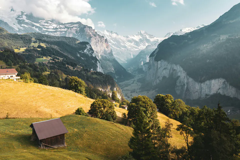 The Lauterbrunnen valley in golden evening light, a hay barn in the foreground